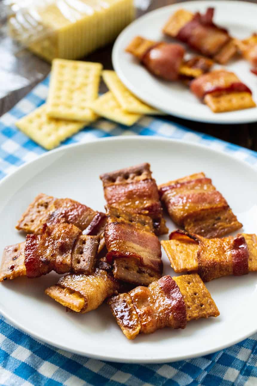 Bacon Wrapped Crackers o a white plate with crackers in background.