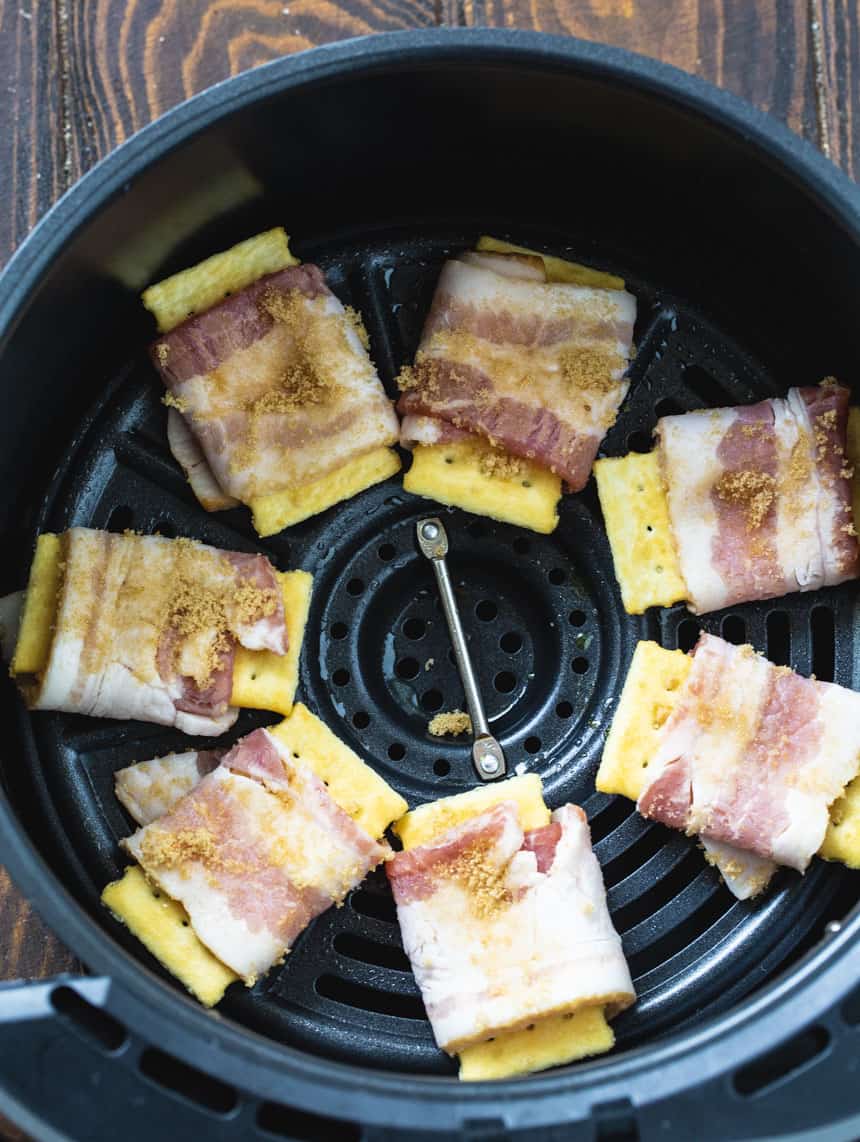 Crackers wrapped with uncooked bacon in air fryer.