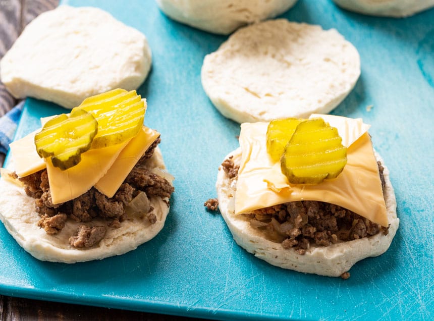 Ground beef mixture and cheese on a biscuit piece.