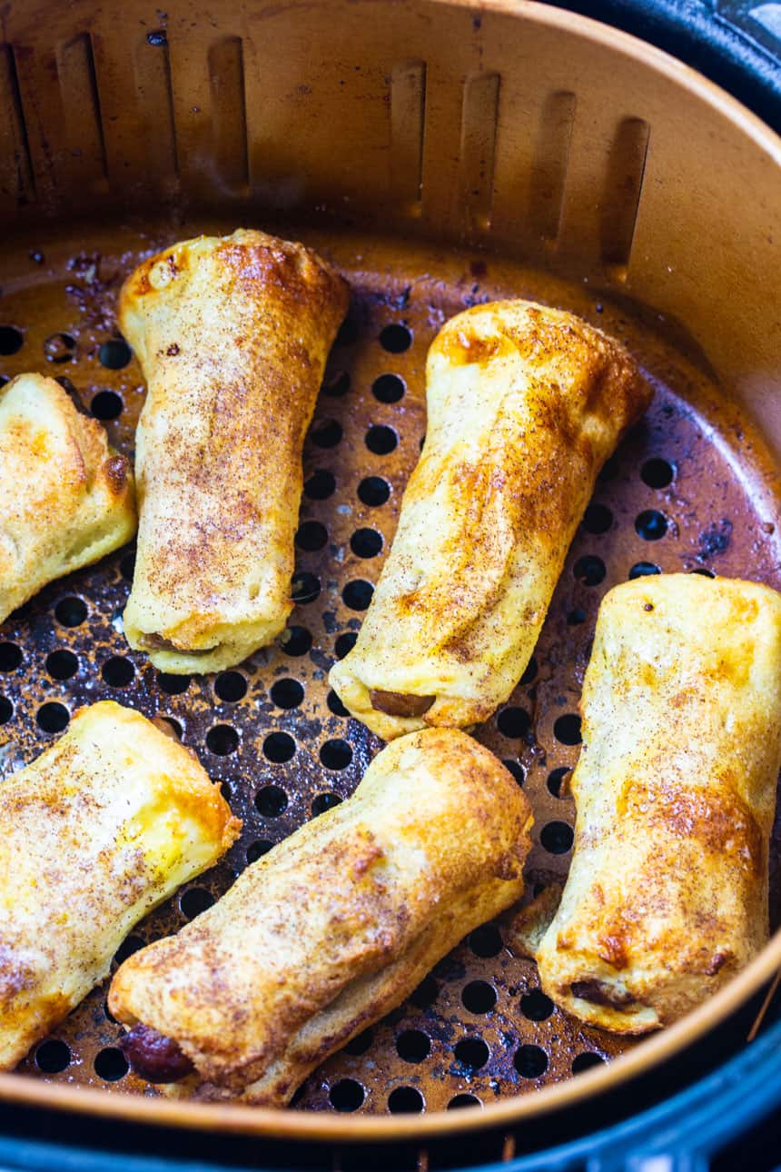 French Toast sausage Roll-Ups in air fryer basket.