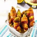 Air Fryer Bacon Wrapped Avocado Fries in a small metal basket.