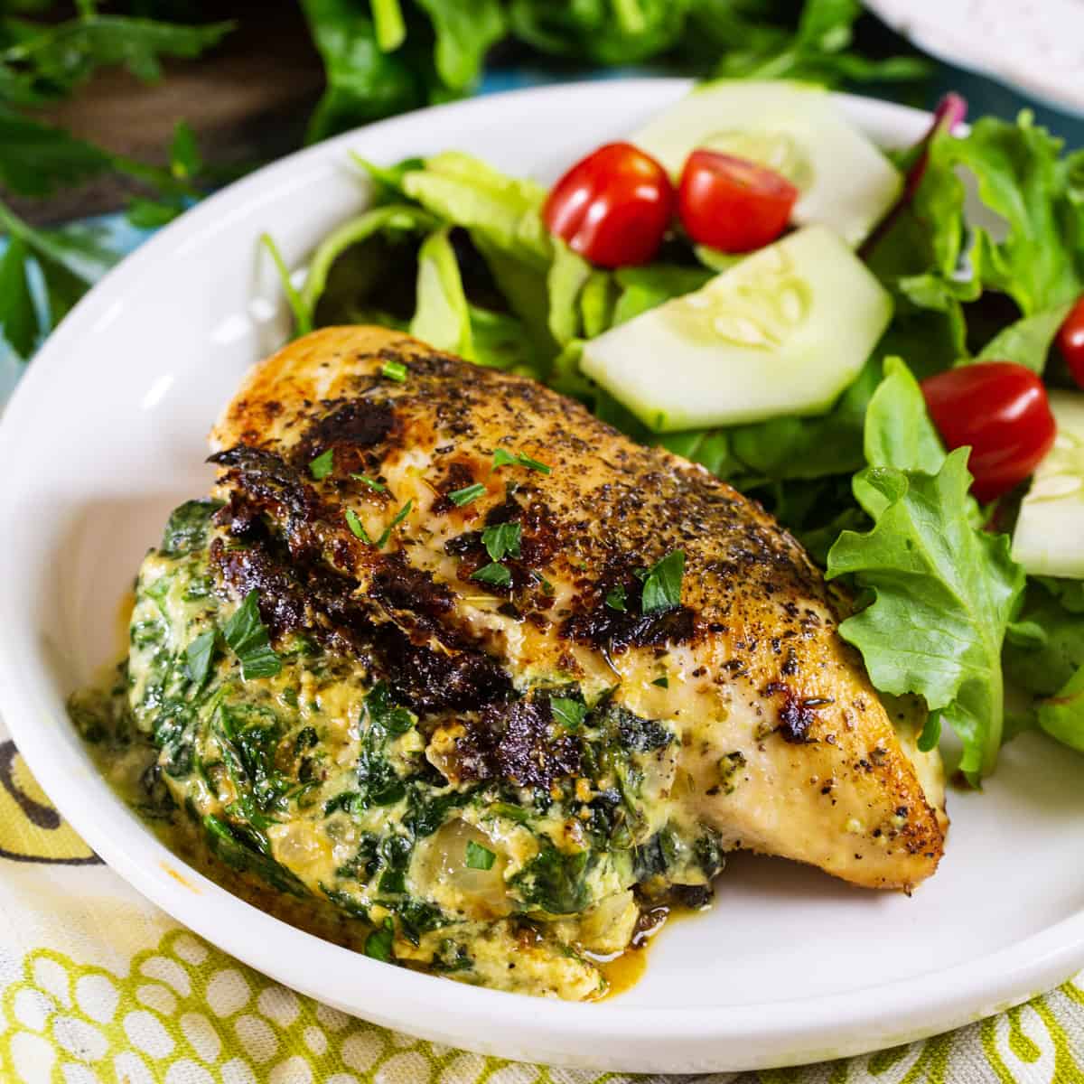 Spinach Ricotta Stuffed Chicken on plate with salad.