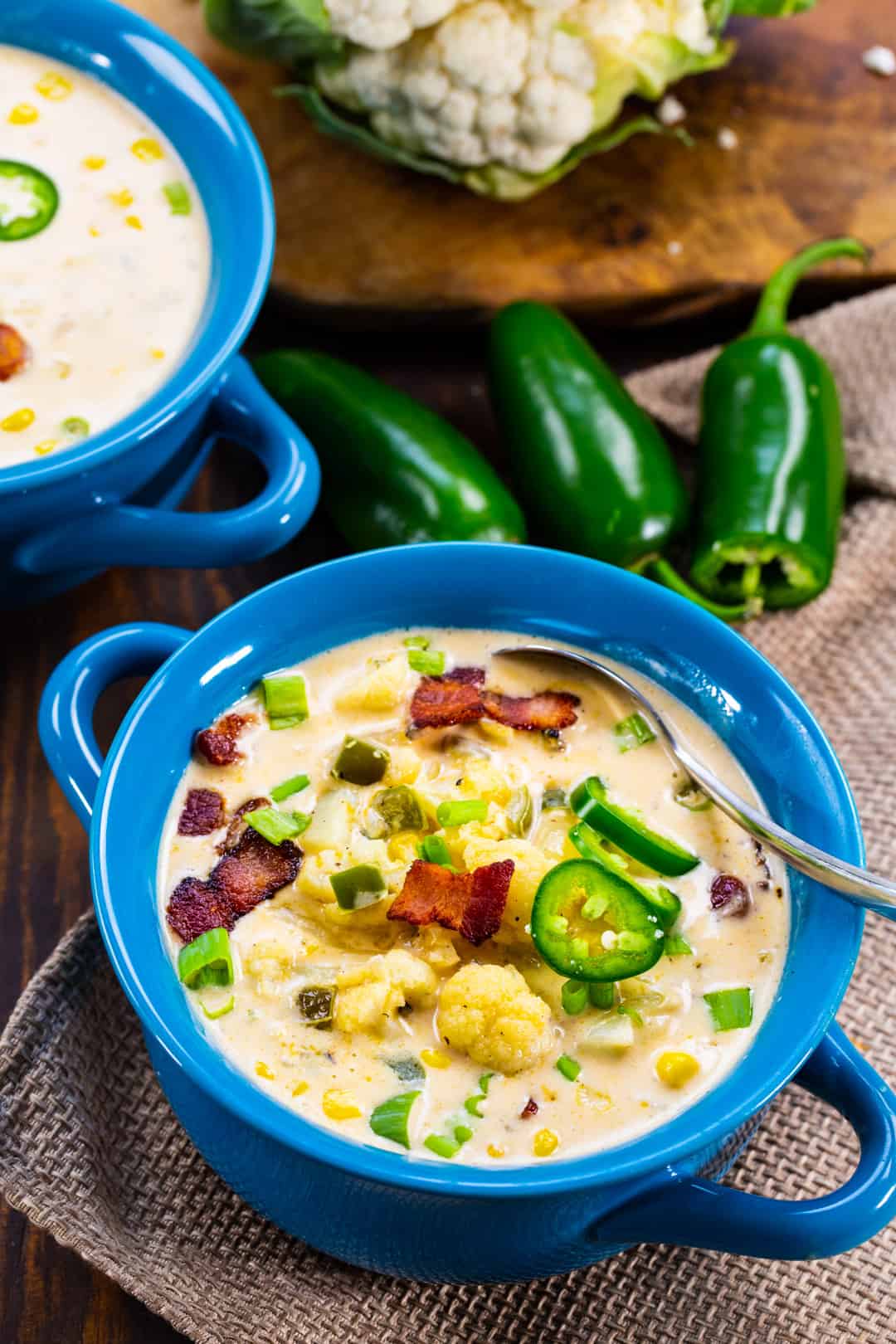 Soup in 2 bowls and fresh jalapeno peppers.